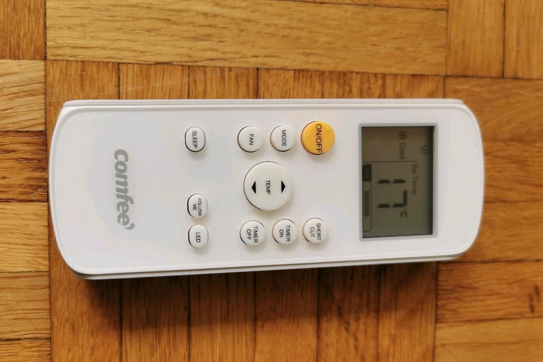 Die Fernbedienung der Comfee Mobile 7000 (Easy Cool 2.0)liegt auf dem Boden und wird in Nahaufnahme gezeigt.